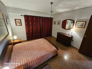 グラオ・デ・カステヨンにあるFelicidad del marのベッドルーム1室(ベッド1台、ドレッサー、鏡付)