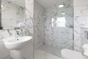a white bathroom with a sink and a shower at The Sir Thomas Hotel in Liverpool +41 photos