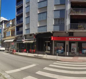 una strada cittadina vuota con un edificio con un negozio di Casa Jesús a Sarria