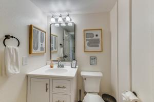 a bathroom with a toilet and a sink and a mirror at Desert Home with Private Pool in Mesa Near Golf in Mesa +22 photos