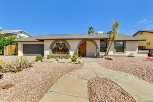 a house with a palm tree in front of it at Spacious Desert Oasis in Mesa with Private Pool! in Mesa