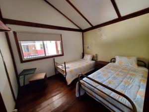 a bedroom with two beds and a window at Casa Noe - Noe House in Macas