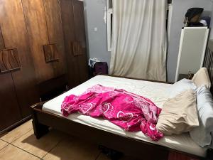 ein Bett mit einer rosa Decke darüber in der Unterkunft Maqueda 2. Sanjo in Malabo