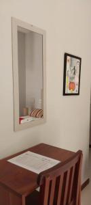 a mirror on a white wall with a wooden table at Pousada Munguba in Jericoacoara