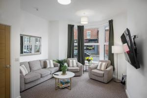a living room with a couch and chairs and a tv at Blackpool Central Springfield Apartments Spacious Comfort in Blackpool