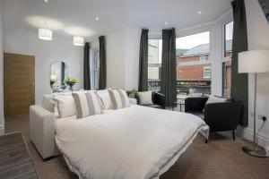 a bedroom with a white bed and a large window at Blackpool Central Springfield Apartments Spacious Comfort in Blackpool