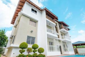 a white building with trees in front of it at Luxury Sky Blue in Jarabacoa