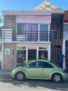een groene auto geparkeerd voor een gebouw bij GR20acd Elva in Cuauhtémoc
