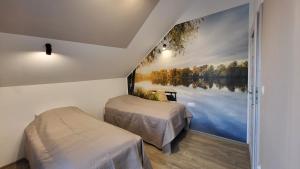 duas camas num quarto com um quadro na parede em Rybitwy Residence em Mielno