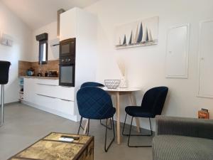 a kitchen with a table and chairs in a room at 36 2 L'air marin maison duplex grande terrasse in Narbonne