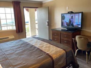 Habitación de hotel con cama y TV de pantalla plana. en Arlington Inn en Riverside