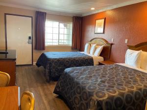 a hotel room with two beds and a window at Arlington Inn in Riverside