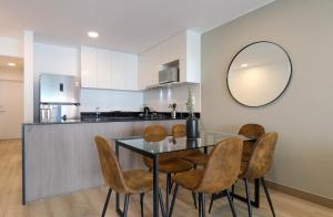 a kitchen with a table and chairs and a mirror at One By Wynwood House in Lima