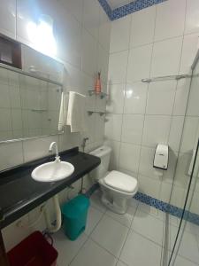 a bathroom with a sink and a toilet and a mirror at Pousada Munguba in Jericoacoara +48 photos