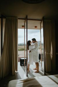 a bride and groom hugging in front of a mirror at Equ Hotel de Tierra in El Porvenir