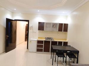 a kitchen with a table and chairs in a room at نسيم جوري للشقق المخدومة Naseem Jouri Serviced Apartments in Taif