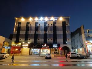 un bâtiment avec des voitures garées dans un parking la nuit dans l'établissement نسيم جوري للشقق المخدومة Naseem Jouri Serviced Apartments, à Taif 9 autres photos