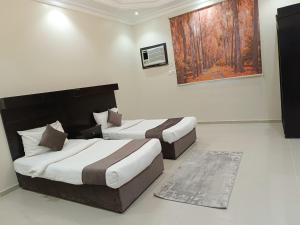 - une chambre d'hôtel avec 2 lits et un tapis dans l'établissement نسيم جوري للشقق المخدومة Naseem Jouri Serviced Apartments, à Taif