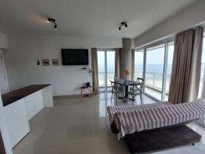 a living room with a table and a view of the ocean at Book Santos - Unlimited 1419 - Studio Frente Mar in Santos +37 photos