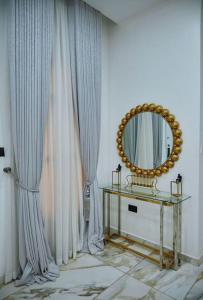 a room with a mirror and a table and curtains at Exquisite 3BR Penthouse with Waterfront Views in Lekki