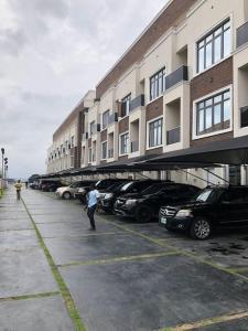 a man standing in a parking lot in front of a building at Exquisite 3BR Penthouse with Waterfront Views in Lekki