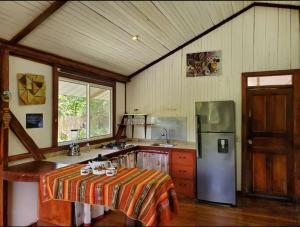 a kitchen with a refrigerator and a table in it at Casa Noe - Noe House in Macas