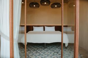 a bedroom with a bunk bed with white sheets at Equ Hotel de Tierra in El Porvenir