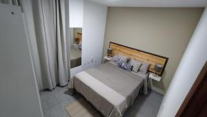 Un dormitorio pequeño con una cama y un espejo. en CASA JOSE "Acogedor Apartamento cerca de la playa", en Candelaria