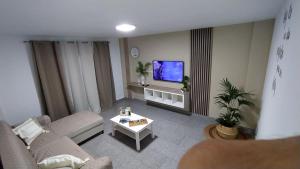 Una sala de estar con un sofá y un televisor. en CASA JOSE "Acogedor Apartamento cerca de la playa", en Candelaria