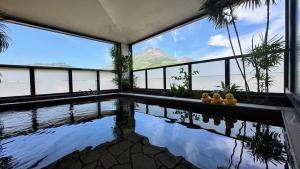 a house with a swimming pool with a view of the mountains at Yufuin Akarinoyado in Yufuin