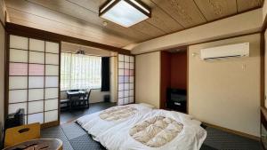 sypialnia z łóżkiem w środku pokoju w obiekcie Yufuin Akarinoyado w mieście Yufu