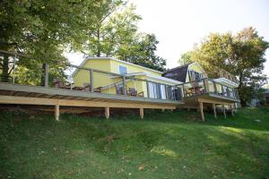 ein großes gelbes Haus mit einer großen Terrasse in der Unterkunft Sunset Haven - Lakeside Retreat in GOTL in Geneva