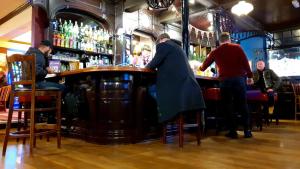 a group of people sitting at a bar at The Grapes Pub in Southampton