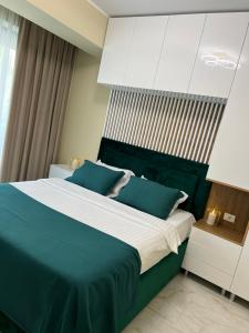 1 dormitorio con 1 cama grande con almohadas azules en Apartament Andreea, en Mamaia Nord – Năvodari