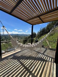 a hammock on a balcony with a view at Montecielo Hosting in Guatapé
