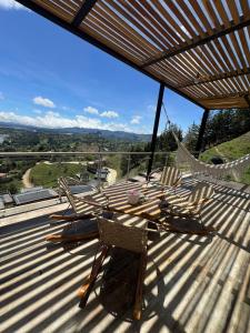 a deck with chairs and a hammock on a roof at Montecielo Hosting in Guatapé