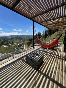 a hammock on the roof of a house with a view at Montecielo Hosting in Guatapé