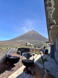 dos personas sosteniendo copas de vino con una montaña en el fondo en Casa Ze & sonia, en Portela