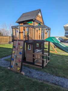 a wooden playset with a slide in a yard at Hotel Motel Granby in Granby