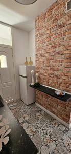 グダニスクにあるApartament Gdańskaのレンガの壁の客室で、冷蔵庫が備わります。
