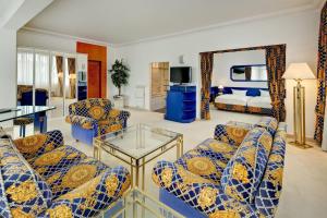 a living room with blue and yellow furniture and a bed at Hotel La Strada in Kassel