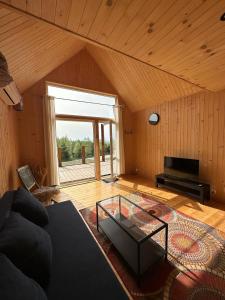 a living room with a couch and a glass table at Sunny Houses domki rekreacyjne in Sobótka