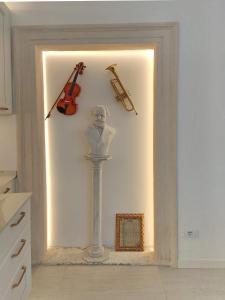 eine Wand mit einer Statue und ein paar Instrumenten darauf in der Unterkunft Arena and Opera Love - Historic House Amorino at "Palazzo Tiolo" Palace in Verona