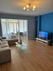 ein Wohnzimmer mit einem Sofa und einem TV in der Unterkunft Tirana Centre New Lions Gate 3 Apartment in Tirana