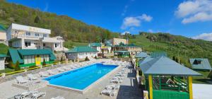 un complejo con piscina, sillas y montaña en Bali Mountain resort Montenegro en Bijelo Polje