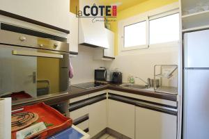 cocina con armarios blancos y encimera en Cap Rousset - 4 couchages, en Carry-le-Rouet