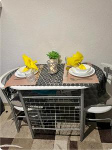 a table with plates and yellow napkins on it at Wohnung nähe Porsche Museum in Stuttgart