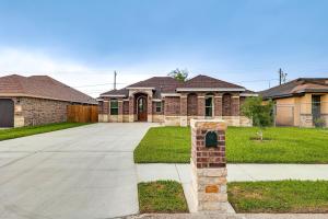 a large brick house with a driveway at Weslaco Home with Fenced Yard 2 Mi to Downtown in Weslaco