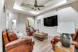 a living room with leather furniture and a flat screen tv at Weslaco Home with Fenced Yard 2 Mi to Downtown in Weslaco