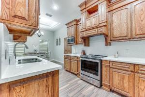 a kitchen with wooden cabinets and a sink at Weslaco Home with Fenced Yard 2 Mi to Downtown in Weslaco